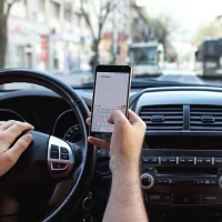 driver-holding-a-phone-with-both-hands-inside-a-car
