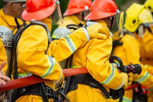 Firefighters spraying high pressure water to fire with copy space, Big bonfire in training, Firefighter wearing a fire suit for safety under the danger case.