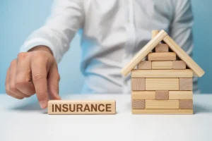Hand Placing Insurance Block Near Wooden House Model Home Insurance and Property Protection Concept Hand Placing Insurance Block Near Wooden House Model Home Insurance and Property Protection Concept