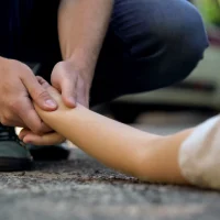 man-holding-hand-of-girl-lying-on-road
